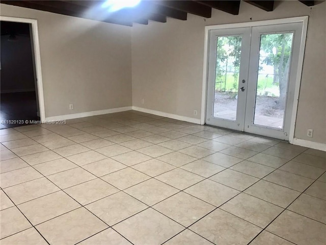 empty room featuring french doors, light tile patterned floors, and beamed ceiling