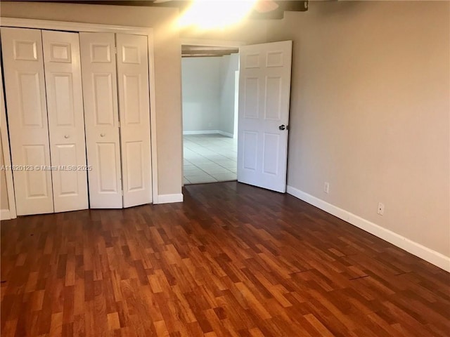 unfurnished bedroom featuring dark wood-style floors and a closet