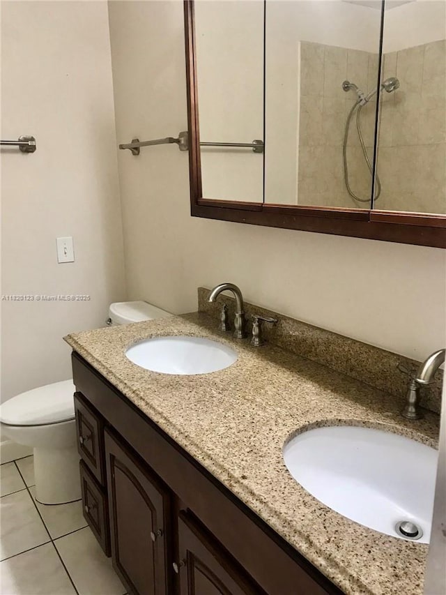full bathroom featuring double vanity, a tile shower, and tile patterned floors