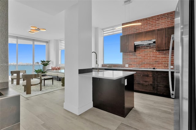 725 NE 22nd St Unit 16A, Miami, FL 33137 - kitchen with freestanding refrigerator, under cabinet range hood, light countertops, pendant lighting, and black electric cooktop