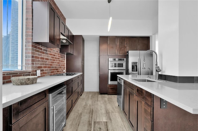 725 NE 22nd St Unit 16A, Miami, FL 33137 - kitchen featuring wine cooler, appliances with stainless steel finishes, dark brown cabinets, light wood-type flooring, and under cabinet range hood