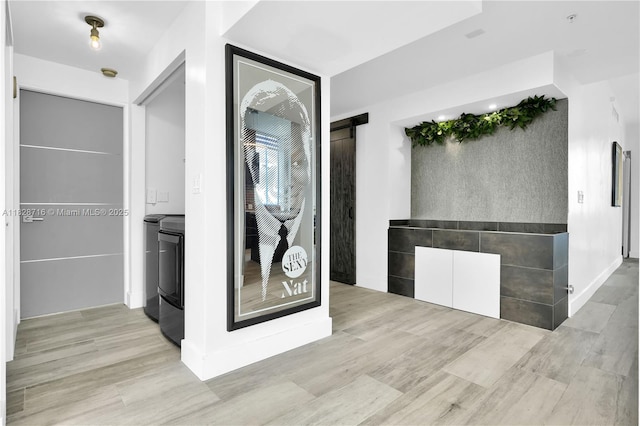 725 NE 22nd St Unit 16A, Miami, FL 33137 - hall with washer and dryer and wood finished floors