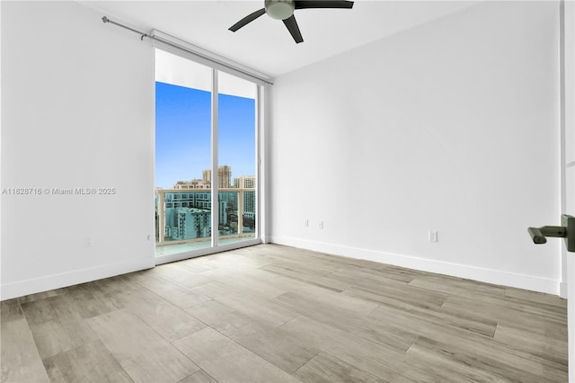 725 NE 22nd St Unit 16A, Miami, FL 33137 - unfurnished room featuring a wall of windows, ceiling fan, and wood finished floors
