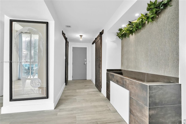 725 NE 22nd St Unit 16A, Miami, FL 33137 - hall with a barn door and light wood-type flooring