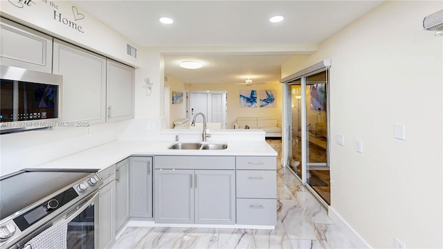 889 Hamilton Dr Unit 889B, Homestead, FL 33034 - kitchen featuring appliances with stainless steel finishes, light marble finish floors, gray cabinetry, a peninsula, and recessed lighting