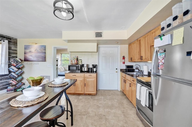 2435 Wilson St, Hollywood, FL 33020 - kitchen featuring stainless steel appliances, dark countertops, tasteful backsplash, and light tile patterned flooring
