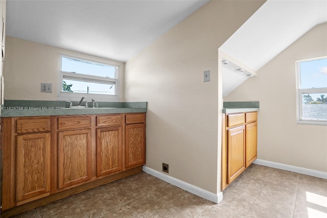 212 SW 11th St, Dania Beach, FL 33004 - kitchen with lofted ceiling, brown cabinetry, and healthy amount of natural light