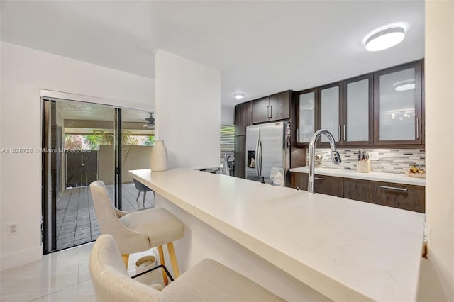 9255 SW 125th Ave Unit 108R, Miami, FL 33186 - kitchen with stainless steel fridge, dark brown cabinets, a kitchen bar, and light tile patterned floors