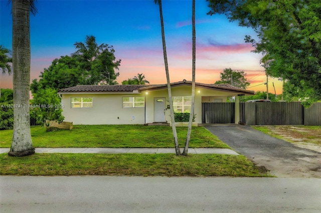 6601 Branch St, Hollywood, FL 33024 - view of front of property featuring asphalt driveway, stucco siding, an attached carport, and a tile roof