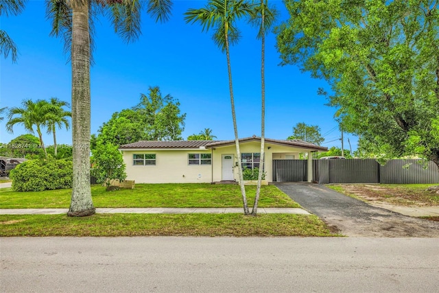 6601 Branch St, Hollywood, FL 33024 - ranch-style home featuring stucco siding, asphalt driveway, and an attached carport