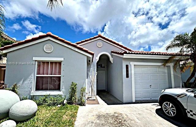 1988 SE 12th St, Homestead, FL 33035 - view of exterior entry with stucco siding and a tiled roof