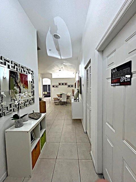 1988 SE 12th St, Homestead, FL 33035 - dining space featuring a textured ceiling, light tile patterned floors, arched walkways, and lofted ceiling