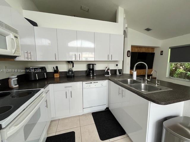 1988 SE 12th St, Homestead, FL 33035 - kitchen featuring white appliances, dark countertops, and light tile patterned flooring