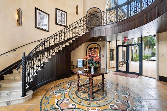 3055 NW 126th Ave Unit 107, Sunrise, FL 33323 - foyer entrance featuring french doors, stairs, a towering ceiling, and stone tile floors