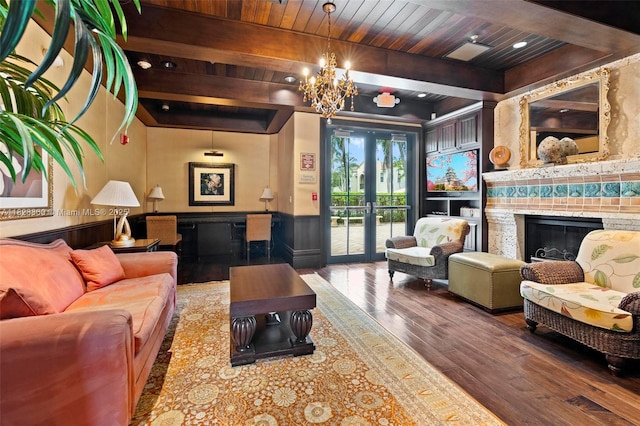 3055 NW 126th Ave Unit 107, Sunrise, FL 33323 - living room with hardwood / wood-style floors, a wainscoted wall, a glass covered fireplace, a chandelier, and french doors