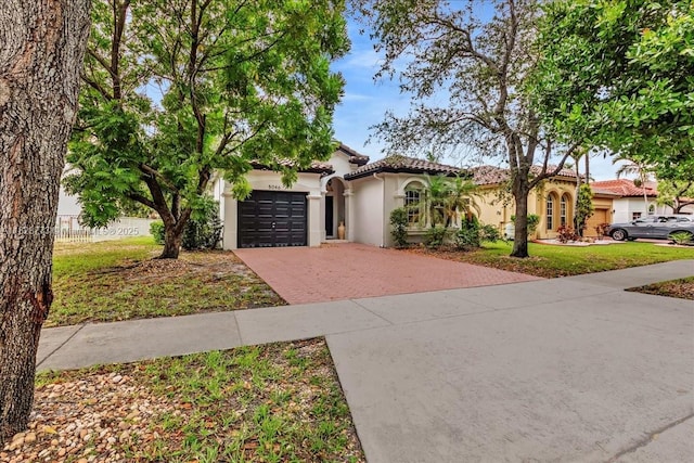 5046 SW 137th Ter, Miramar, FL 33027 - mediterranean / spanish home with decorative driveway, a garage, stucco siding, a tile roof, and a front lawn