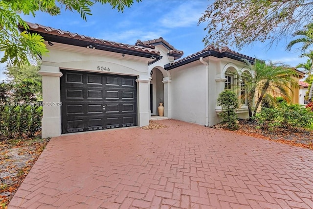 5046 SW 137th Ter, Miramar, FL 33027 - mediterranean / spanish house with decorative driveway, a garage, stucco siding, and a tile roof