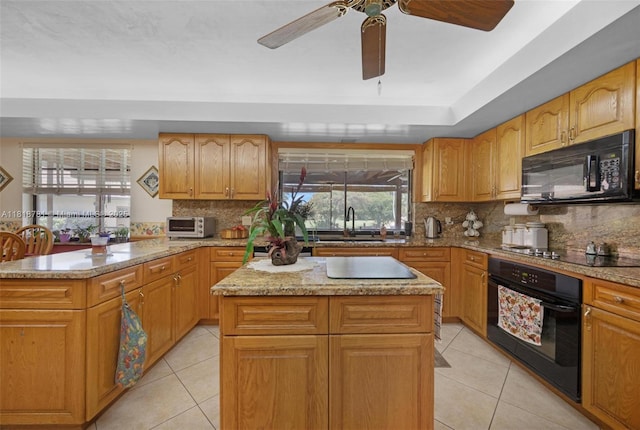 31260 SW 202nd Ave, Homestead, FL 33030 - kitchen featuring black appliances, light tile patterned floors, a center island, and light stone counters