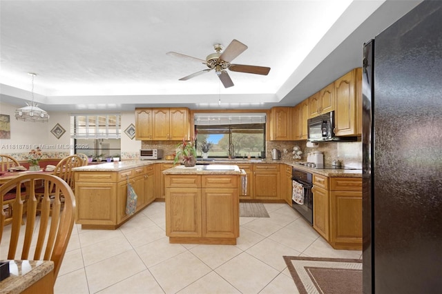 31260 SW 202nd Ave, Homestead, FL 33030 - kitchen featuring black appliances, a tray ceiling, a peninsula, and ceiling fan