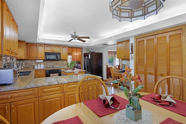 31260 SW 202nd Ave, Homestead, FL 33030 - kitchen featuring black appliances, ceiling fan, tasteful backsplash, a raised ceiling, and a peninsula