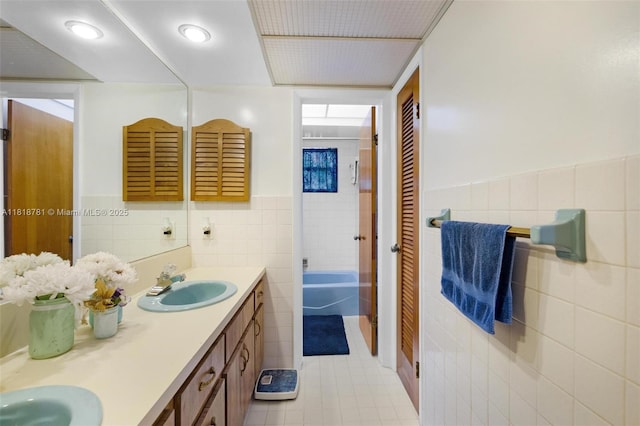 31260 SW 202nd Ave, Homestead, FL 33030 - bathroom with tile walls, double vanity, tile patterned flooring, a wainscoted wall, and a closet