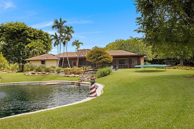 31260 SW 202nd Ave, Homestead, FL 33030 - rear view of house featuring a trampoline, a sunroom, and a lawn