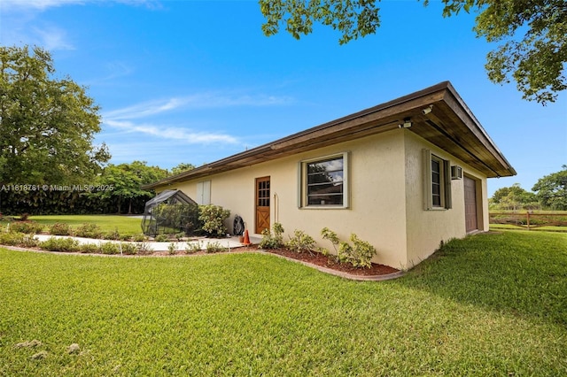 31260 SW 202nd Ave, Homestead, FL 33030 - view of side of home featuring stucco siding, a lawn, and a garage