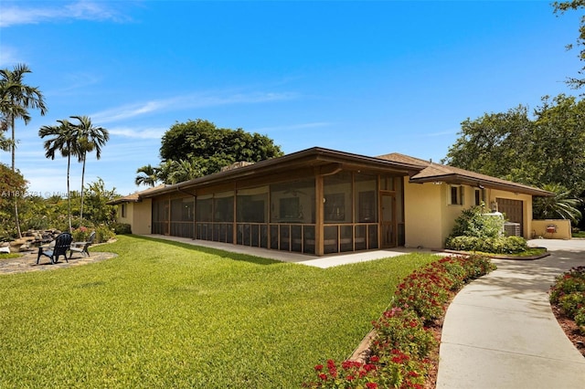31260 SW 202nd Ave, Homestead, FL 33030 - view of green lawn featuring a sunroom, a garage, and concrete driveway
