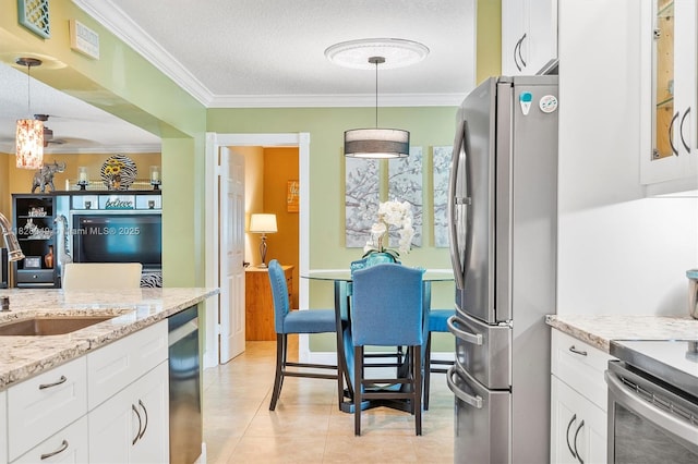 7306 NW 95th Way, Tamarac, FL 33321 - kitchen with stainless steel appliances, crown molding, white cabinetry, decorative light fixtures, and light stone countertops