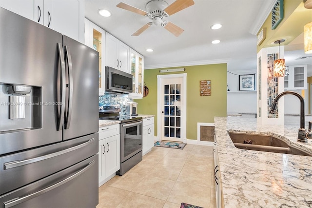 7306 NW 95th Way, Tamarac, FL 33321 - kitchen featuring appliances with stainless steel finishes, glass insert cabinets, white cabinetry, backsplash, and light stone countertops