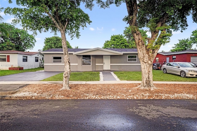 4290 NW 38th Ave, Lauderdale Lakes, FL 33309 - view of front of home with stucco siding, a front yard, and driveway