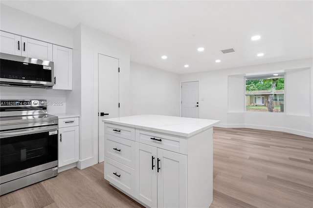 4290 NW 38th Ave, Lauderdale Lakes, FL 33309 - kitchen with appliances with stainless steel finishes, light wood-type flooring, recessed lighting, white cabinetry, and light stone countertops