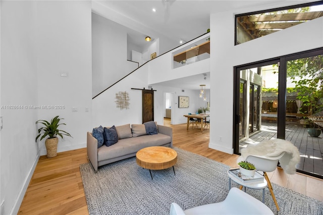 2427 Tequesta Ln, Miami, FL 33133 - living room featuring a high ceiling, light wood-style flooring, and a barn door