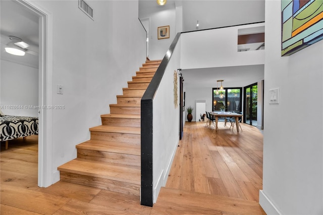 2427 Tequesta Ln, Miami, FL 33133 - stairs featuring hardwood / wood-style floors and a high ceiling