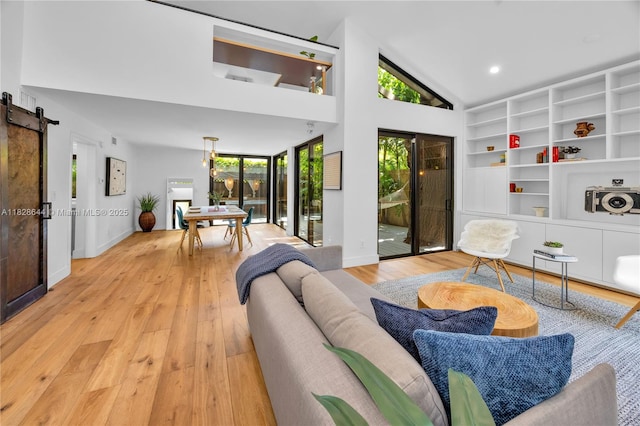 2427 Tequesta Ln, Miami, FL 33133 - living room featuring a barn door, hardwood / wood-style flooring, high vaulted ceiling, built in shelves, and recessed lighting