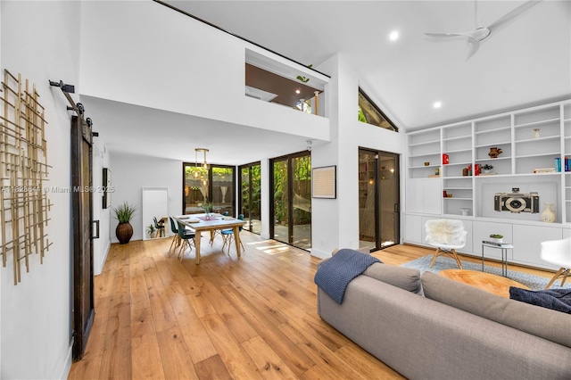 2427 Tequesta Ln, Miami, FL 33133 - living area featuring a barn door, light wood-style flooring, high vaulted ceiling, and recessed lighting