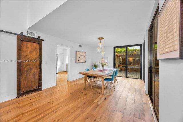 2427 Tequesta Ln, Miami, FL 33133 - dining room with a barn door and light wood-style flooring