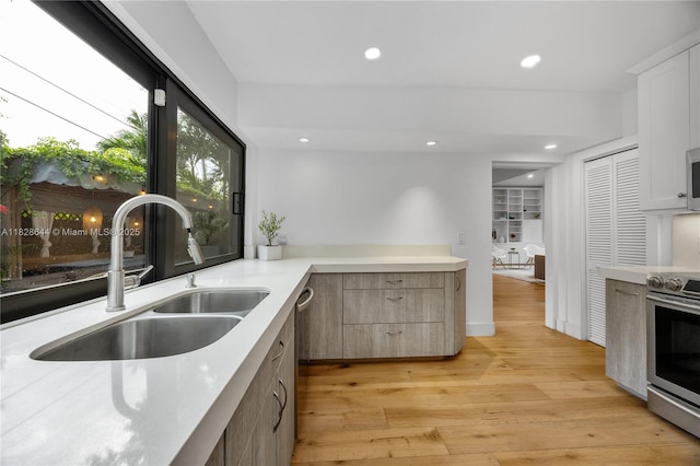 2427 Tequesta Ln, Miami, FL 33133 - kitchen featuring appliances with stainless steel finishes, light wood-style flooring, light countertops, recessed lighting, and white cabinets