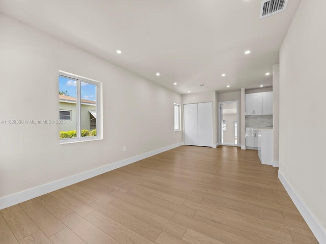 3455 E 1st Ct, Hialeah, FL 33013 - unfurnished living room featuring light wood-type flooring and recessed lighting