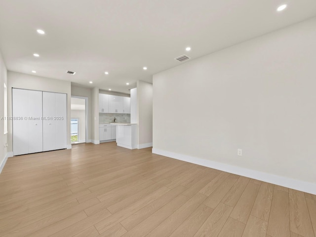 3455 E 1st Ct, Hialeah, FL 33013 - unfurnished living room featuring light wood-style flooring and recessed lighting