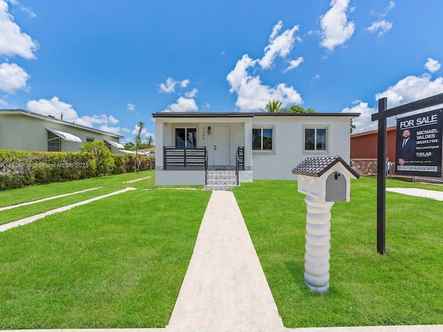 3455 E 1st Ct, Hialeah, FL 33013 - view of front of property featuring a front lawn, a porch, and stucco siding