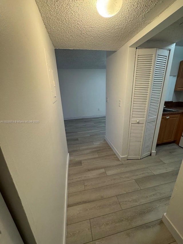 8075 NW 7th St Unit 318, Miami, FL 33126 - hallway featuring wood tiled floors and a textured ceiling
