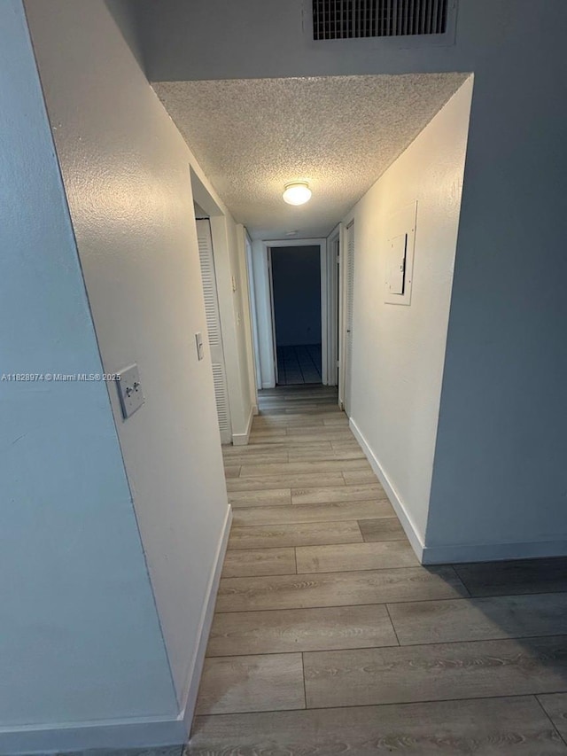 8075 NW 7th St Unit 318, Miami, FL 33126 - hallway featuring light wood finished floors and a textured ceiling