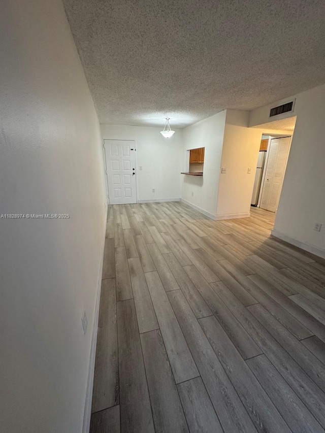 8075 NW 7th St Unit 318, Miami, FL 33126 - unfurnished room featuring light wood finished floors and a textured ceiling