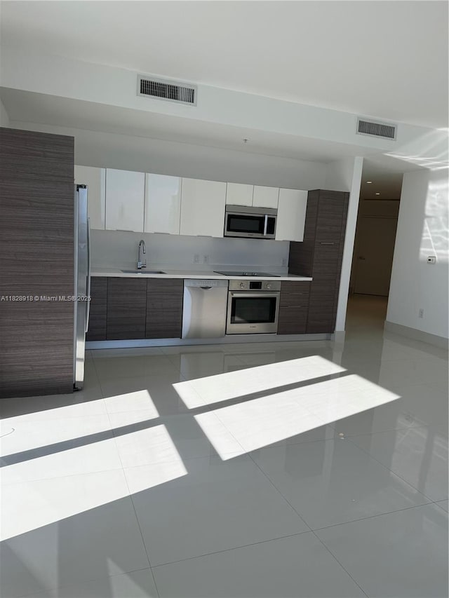 1010 SW 2nd Ave Unit Ph06, Miami, FL 33130 - kitchen featuring appliances with stainless steel finishes, white cabinetry, modern cabinets, light tile patterned floors, and light countertops