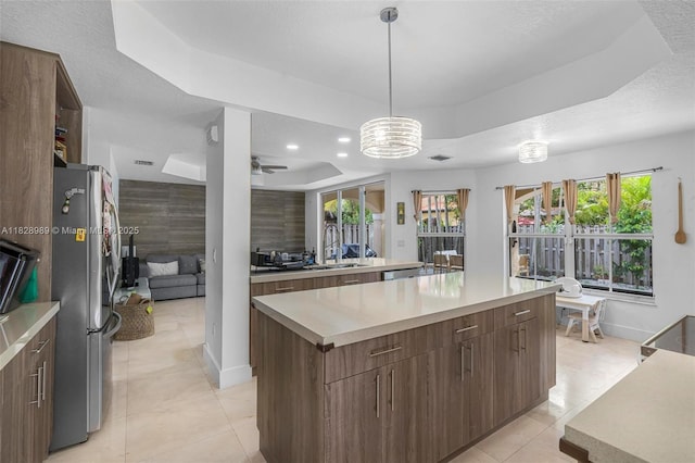 2620 SW 150th Ct, Miami, FL 33185 - kitchen featuring a tray ceiling, freestanding refrigerator, a kitchen island, light countertops, and modern cabinets