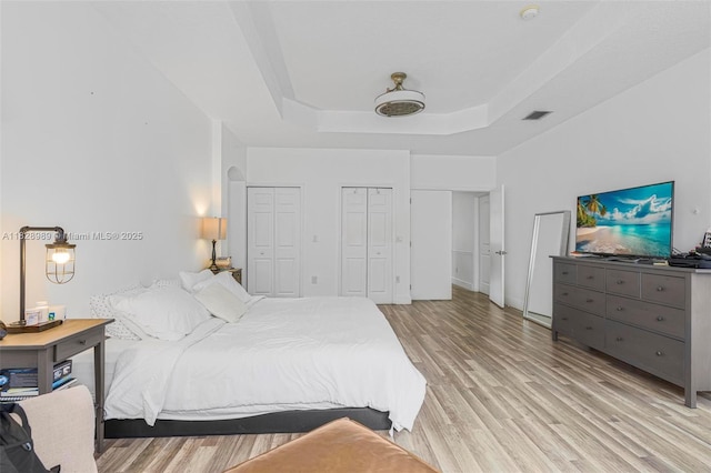 2620 SW 150th Ct, Miami, FL 33185 - bedroom with multiple closets, light wood-style floors, and a raised ceiling