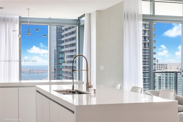 88 SW 7th St Unit 4101, Miami, FL 33130 - kitchen featuring a wall of windows, white cabinetry, pendant lighting, and light countertops