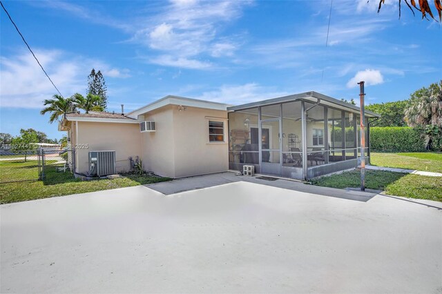16702 NW 73rd Ct, Hialeah, FL 33015 - rear view of house with a sunroom, a patio area, stucco siding, and an AC wall unit