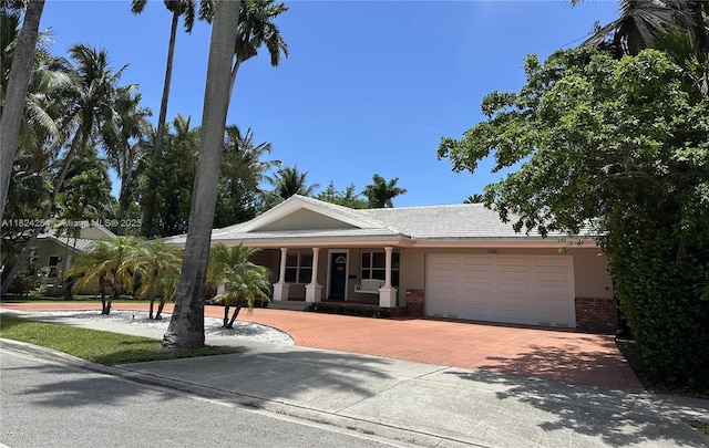 1330 Harrison St, Hollywood, FL 33019 - single story home featuring a garage, decorative driveway, brick siding, a porch, and stucco siding